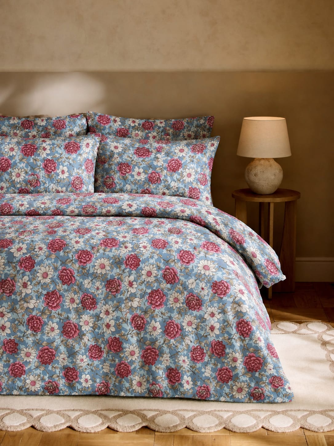 Floral bedding set on a bed with a lamp in the background