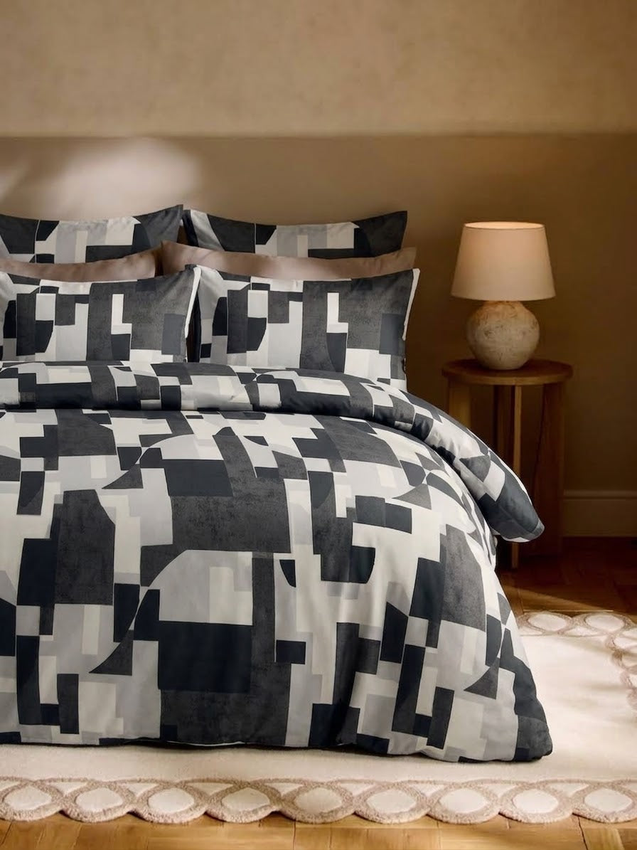 Charcoal Fragments grey and black abstract geometric bedsheet set on a bed