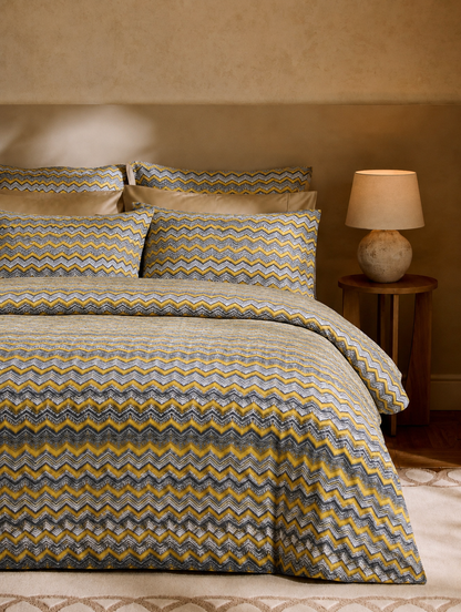 Bed with zigzag patterned bedding in a bedroom setting