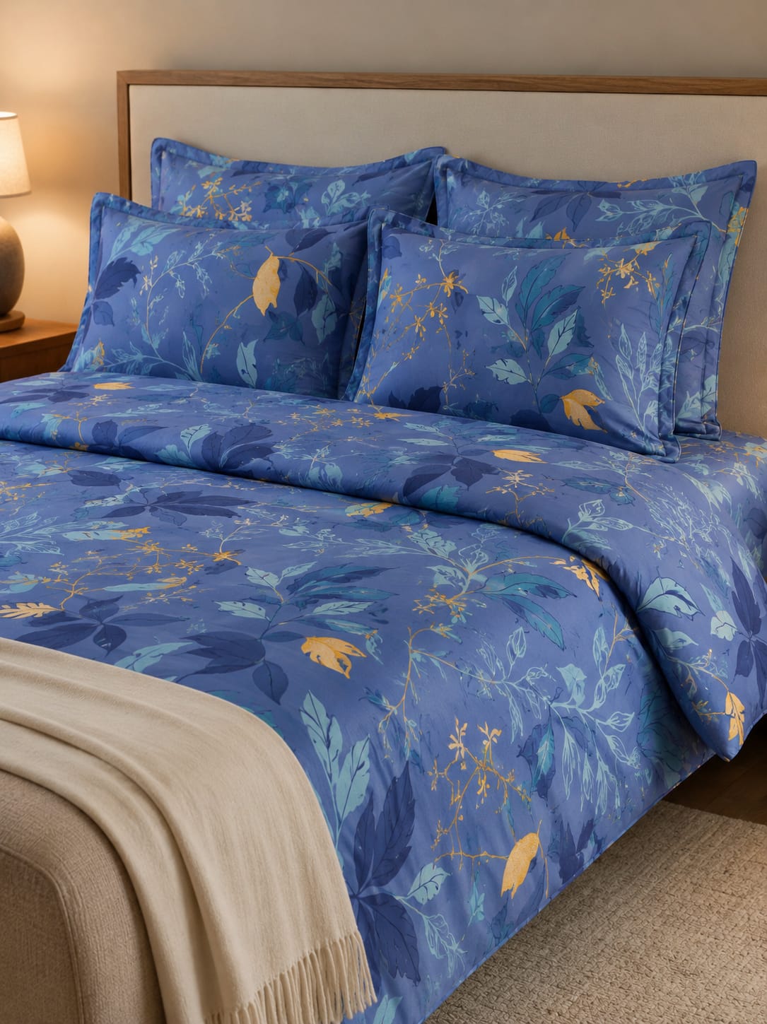 Blue floral patterned bedding set on a bed with a beige headboard.