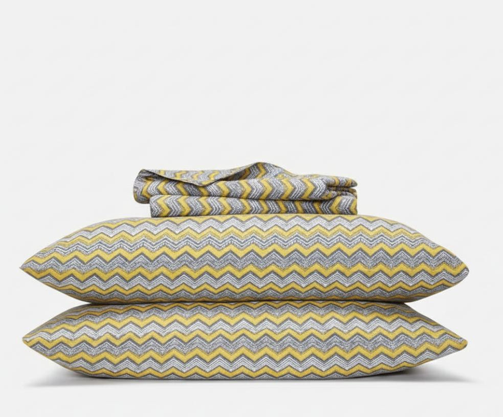 Yellow and gray zigzag patterned pillows on a white background