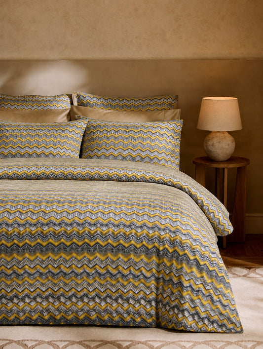 Bed with zigzag patterned bedding in a bedroom setting