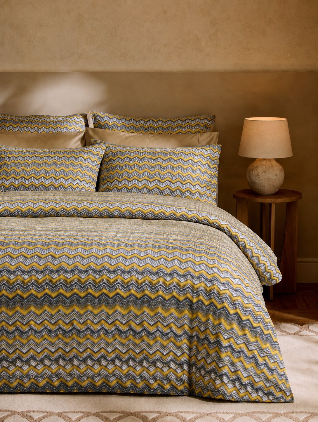 Bed with zigzag patterned bedding in a bedroom setting